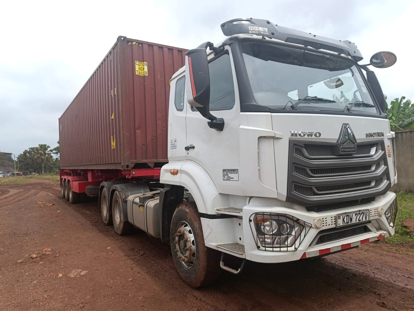 Dontre Outliers HOWO tractor unit with a loaded forty-foot container on a tri-axle skeletal trailer